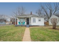 Charming single-story home featuring a cozy front porch with cheerful turquoise chairs at 1957 N Colorado Ave, Indianapolis, IN 46218