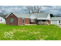 Charming red brick single-story home with well-maintained lawn and detached two-car garage at 2359 S County Road 1050 E, Indianapolis, IN 46231