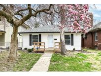 Charming home featuring a cozy front porch and beautiful mature trees at 3559 Carrollton Ave, Indianapolis, IN 46205