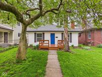 Charming home featuring a vibrant blue front door and a cozy wood porch at 3559 Carrollton Ave, Indianapolis, IN 46205