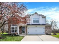Charming two-story home boasts brick and white siding, attached two-car garage and well-manicured lawn at 4345 Elkhorn Dr, Westfield, IN 46062