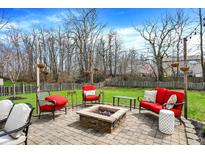 Backyard paver patio with string lights, a fire pit, and comfortable seating creates a welcoming outdoor oasis at 4345 Elkhorn Dr, Westfield, IN 46062
