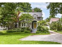 Charming two-story home with a lush front yard and beautiful landscaping, offering great curb appeal at 5718 E Pleasant Run Parkway North Dr, Indianapolis, IN 46219