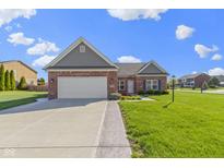 Charming brick home features a well-maintained lawn and attached two-car garage at 6524 Turf Way, Anderson, IN 46013