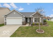 Charming single-story home with stone accents, a well-manicured lawn, and an attached two-car garage at 7951 Busby Bend Dr, Noblesville, IN 46062
