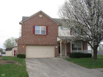 Two-story brick home with an attached two-car garage and flowering tree in front at 10762 Galant Fox Ct, Indianapolis, IN 46234