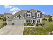 Beautiful two-story home boasts a three-car garage and meticulously landscaped front yard at 13316 Fielding Way, Fishers, IN 46037