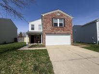 Charming two-story home featuring a brick front, attached garage, and a well-maintained lawn at 1404 Alonzo Pl, Indianapolis, IN 46217