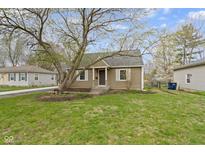 Charming single-Gathering home with a well-maintained lawn and a mature tree in the front yard at 2210 Douglas Rd, Indianapolis, IN 46220