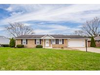 Charming single-story home with a well-manicured lawn and an attached two-car garage at 2511 Ritter Dr, Anderson, IN 46012