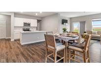 Open-concept dining area featuring a modern table set and seamless flow to the kitchen at 432 Bluestem Ln, Whiteland, IN 46184