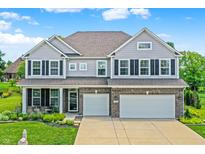 Beautiful two-story home with gray siding, brick accents, and a well-manicured lawn at 7251 Birch Leaf Dr, Indianapolis, IN 46259
