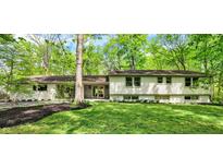 Charming home featuring a well-manicured lawn and beautiful landscaping, complemented by a tree-lined property at 8990 Pickwick Dr, Indianapolis, IN 46260