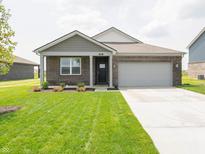 Charming one-story brick home with a well-manicured lawn, landscaping, and attached two car garage at 915 Saddlebrook Farms Blvd, Whiteland, IN 46184
