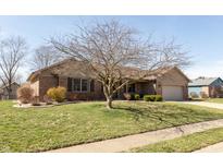 A charming, single story brick home featuring an attached garage, lawn, and mature trees at 1002 Corey Ln, Plainfield, IN 46168