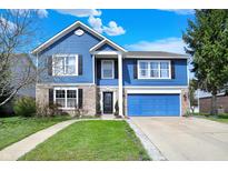 Charming two-story home featuring blue siding, a well-manicured lawn, and an attached two-car garage at 1032 Beal Ct, Indianapolis, IN 46217