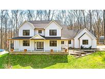 Charming white two-story home with inviting front porch and black trimmed windows on a green lawn at 1037 E Woodall Ct, Martinsville, IN 46151