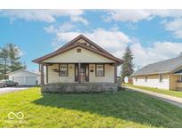 Charming bungalow featuring a covered front porch and well-maintained lawn at 12125 Broadway St, Indianapolis, IN 46236