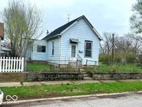 Quaint single-Gathering home with a light blue exterior and a small, fenced-in front yard at 1237 N Sheffield Ave, Indianapolis, IN 46222