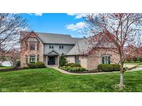 Beautiful brick two-story home boasts mature trees, well-kept lawn and manicured landscaping at 12535 Glendurgan Dr, Carmel, IN 46032