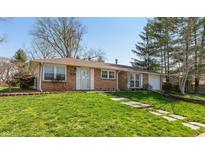 Charming brick ranch-style home with a well-manicured lawn and walkway leading to the front door at 1665 South Dr, Columbus, IN 47203