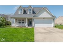 Charming two-story home with a cozy front porch and a well-maintained lawn, featuring a two-car garage at 329 Dogwood Dr, Pendleton, IN 46064