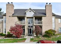 Charming condo featuring a brick facade, balcony, and well-maintained landscaping in a tranquil setting at 3704 Reflections Dr # 4, Indianapolis, IN 46214