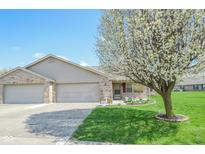 Charming single-story home featuring a well-manicured lawn, flowerbeds, and an attached two-car garage at 3925 Oak Harbor Ln, Indianapolis, IN 46237