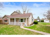 Charming stone home with a covered front porch and manicured lawn at 453 S High School Rd, Indianapolis, IN 46241