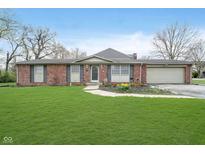 Charming one-story brick home with a well-manicured lawn and attached two-car garage at 5061 Sylvan Rd, Indianapolis, IN 46228