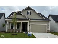 Charming single-story home with neutral siding, a two-car garage, and manicured front lawn and classic architectural details at 5653 Stetson Dr, Whitestown, IN 46052