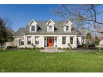 Charming two-story home with manicured lawn, bright orange front door, and white painted brick at 5952 Stafford Rd, Indianapolis, IN 46228
