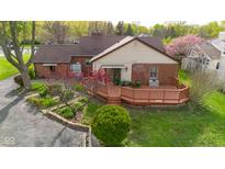 Beautifully landscaped backyard featuring a wooden deck, mature trees, and charming details at 6141 Madison Ave, Indianapolis, IN 46227
