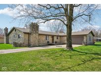 Charming stone home with well-maintained lawn and mature shade tree with a tire swing at 7974 N 500 W, McCordsville, IN 46055