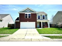 Inviting two-story home featuring a brick facade, attached two-car garage, and well-maintained lawn at 8051 Retreat Ln, Indianapolis, IN 46259
