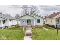 Charming home featuring a well-maintained lawn and a delightful lattice-covered front porch at 831 Wallace Ave, Indianapolis, IN 46201
