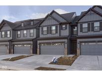 New construction townhouse featuring a gray exterior, attached garage, and manicured lawn at 9738 Behner Dr, Fishers, IN 46250