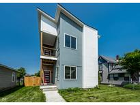 Modern two-story home with gray and white siding, red door, a well-manicured lawn, and a private balcony at 1026 St Peter St, Indianapolis, IN 46203