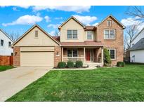 Charming two-story brick home with a well-manicured lawn and inviting front porch at 11247 Reflection Point Dr, Fishers, IN 46037
