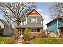 Charming two-story home featuring a brick foundation, cozy porch, and inviting exterior at 1230 N Temple Ave, Indianapolis, IN 46201