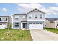 Charming two-story home with a two-car garage, manicured lawn and inviting curb appeal at 13872 N Mardenis W Dr, Camby, IN 46113