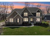 Elegant home with brick facade, well-kept lawn, and professionally landscaped garden beds at 14747 Harvest Glen S Blvd, Fishers, IN 46037