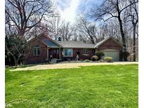 Charming brick ranch-style home with a well-manicured lawn and mature trees creates a welcoming curb appeal at 2143 Sunderland Dr, Martinsville, IN 46151