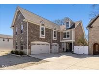 Stunning multi-story home featuring a 3-car garage, brick and stone accents, and a well-manicured front yard at 445 W 86Th St, Indianapolis, IN 46260