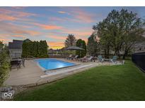 Backyard features an in-ground pool, lounge seating, and a charming fire pit area at 7259 Josiah Ct, Indianapolis, IN 46259