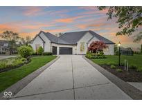 Stunning white brick home boasts a long driveway and beautifully landscaped front yard at 7259 Josiah Ct, Indianapolis, IN 46259