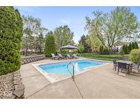 Backyard pool area complete with lounge seating, dining table, mature landscaping, and recreation space at 7259 Josiah Ct, Indianapolis, IN 46259