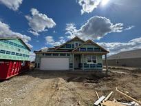 New home construction with a white garage door, covered porch, and blue sky at 895 Saddlebrook Farms Blvd, Whiteland, IN 46184