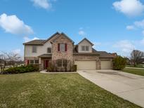 Charming two-story home with a three-car garage, brick accents, and a well-manicured lawn at 9237 Stones Ferry Pl, Indianapolis, IN 46278