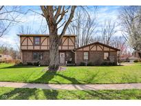 Charming two-story brick home with Tudor-style accents and a well-manicured lawn at 1123 Woodbridge Ln, Indianapolis, IN 46260